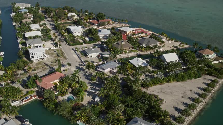 Aerial footage of flying over residential neighborhood in Lower Sugarloaf Key Florida tilting down to showcase the shorelines and beachfront properties