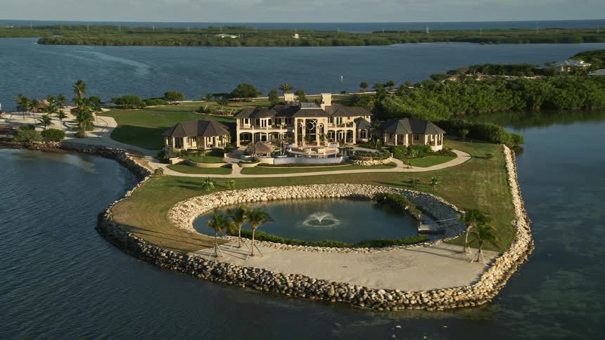A stunning aerial view of a luxurious mansion situated on an island by the coastline of Marathon Florida during dusk
