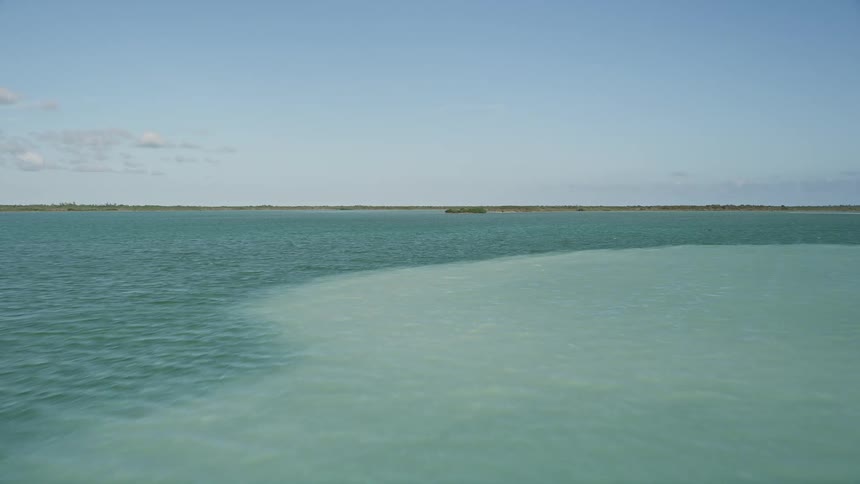 A low-flying aerial view of Upper Sugarloaf Sound Floridas coastline on a sunny day with crystal-clear water showcasing the approach to the shorelines in the spring or summer season