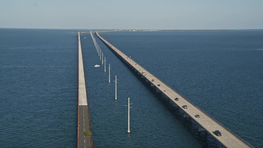 Cars travel along the Seven Mile Bridge on a sunny Florida day as seen from an aerial perspective
