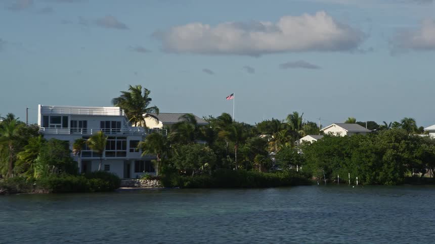 An aerial view of houses on the coastline of Cudjoe Key Florida with a sea shore and neighborhood in sight