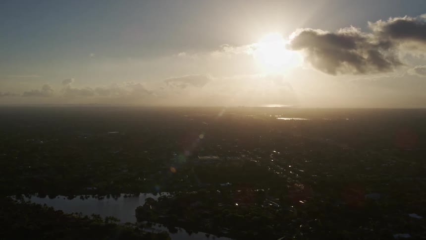 Aerial footage of Kendall Florida at sunrise with partly cloudy skies and a view of the ocean