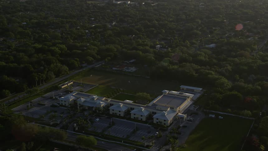 Approaching Riviera Preparatory School at sunrise aerial footage captures a partly cloudy morning in Kendall Florida