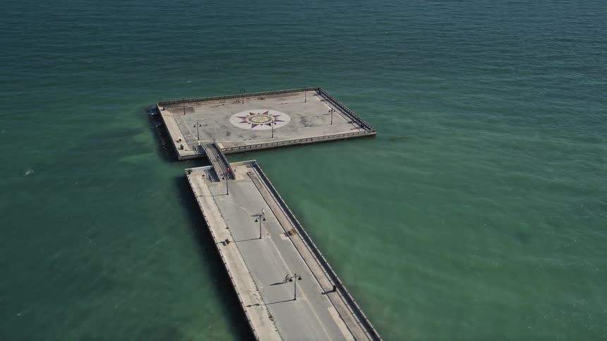 An aerial view of the White Street Pier in Key West Florida with people biking and walking on the boardwalk