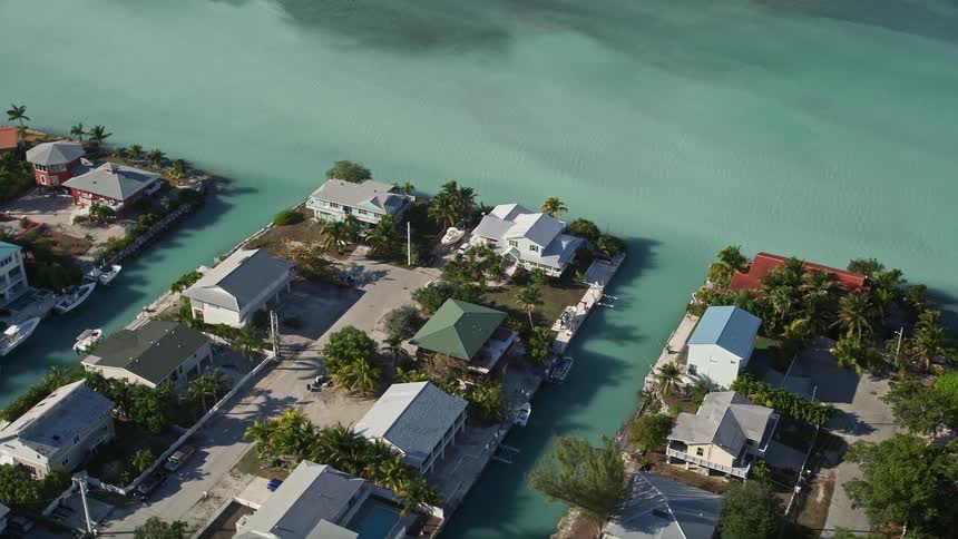 Flying over a suburban neighborhood along the canals of Big Coppitt Key with boats parked at the waters edge