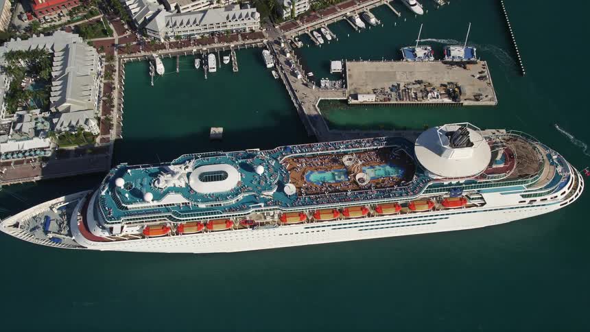 An aerial view of a Royal Caribbean Cruise Ship approaching and docked at Key West Florida with a tilting down motion