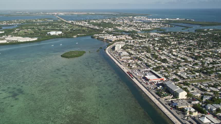 Flying over North Roosevelt Boulevard and approaching Key West Florida revealing Stock Island amidst the coastal communities residential areas and shorelines on the Gulf Coast during a sunny day
