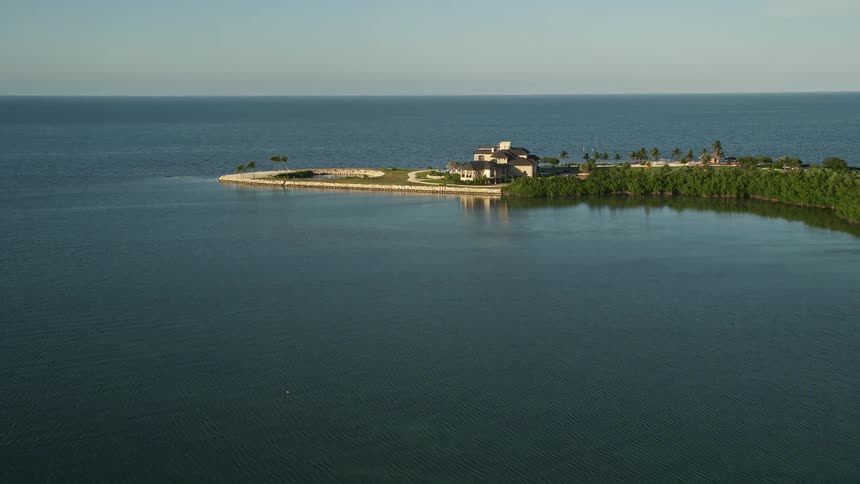 A stunning aerial view of a luxurious mansion situated near the coastline of Marathon Florida at sunset