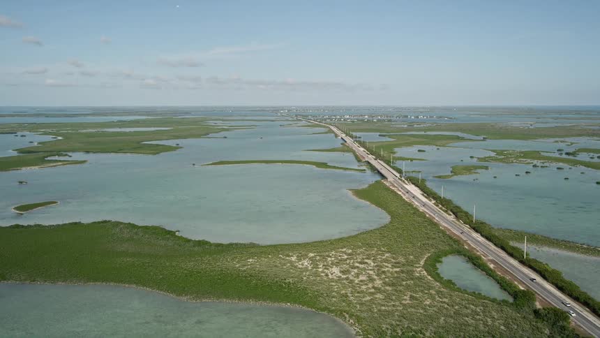 Captivating aerial view of cars driving on Overseas Highway in Saddlebunch Keys Florida surrounded by lakes and mangroves during a sunny day
