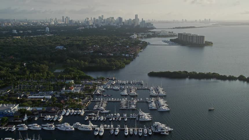 A stunning sunrise aerial view of Miamis coastline including marinas filled with boats the Downtown skyline and Coconut Grove Florida