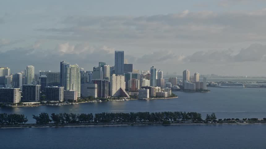 A breathtaking aerial view of downtown Miami cityscape during sunrise covering the coastline and Biscayne Bay