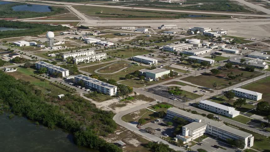 Flying over Naval Air Station Key West and the Florida Keys coastline on a sunny day with a side view of the military base and apartments on the peninsula