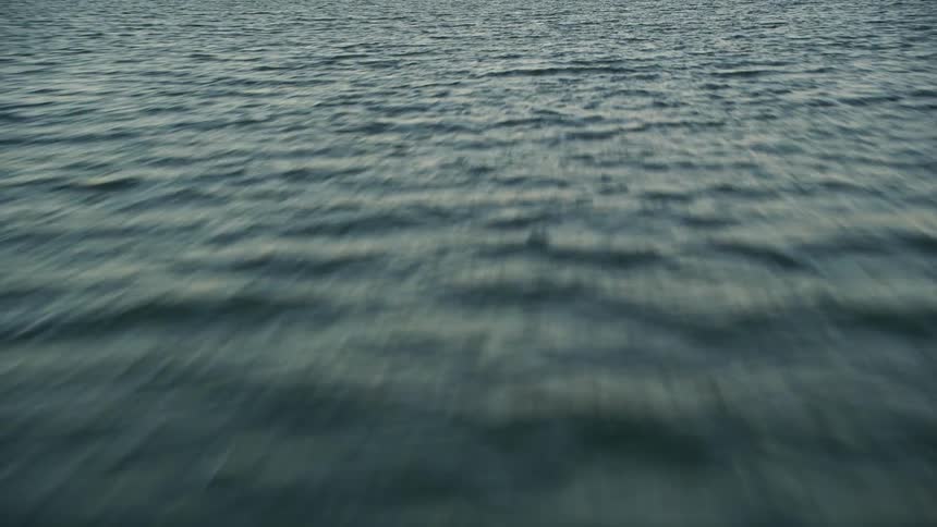 Low-flying aerial footage of a sunny Florida evening approaching Islamorada FL over open water with sunset over the ocean and nature vistas