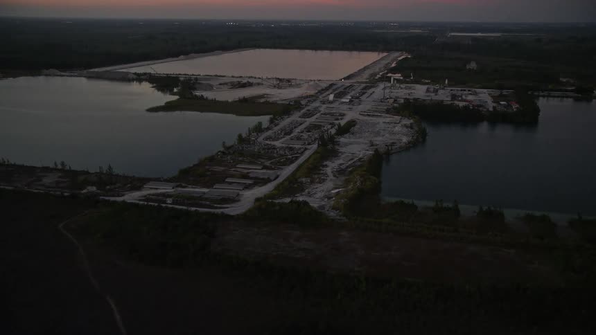 Approaching a quarry at twilight a aerial shot captures the waterfront industrial area of Homestead Florida on the Gulf Coast