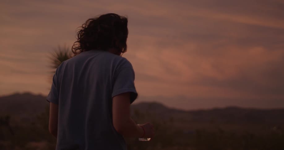 A woman walking outside at sunset in the mountains