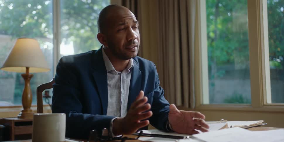 A man chats with a client in a home office