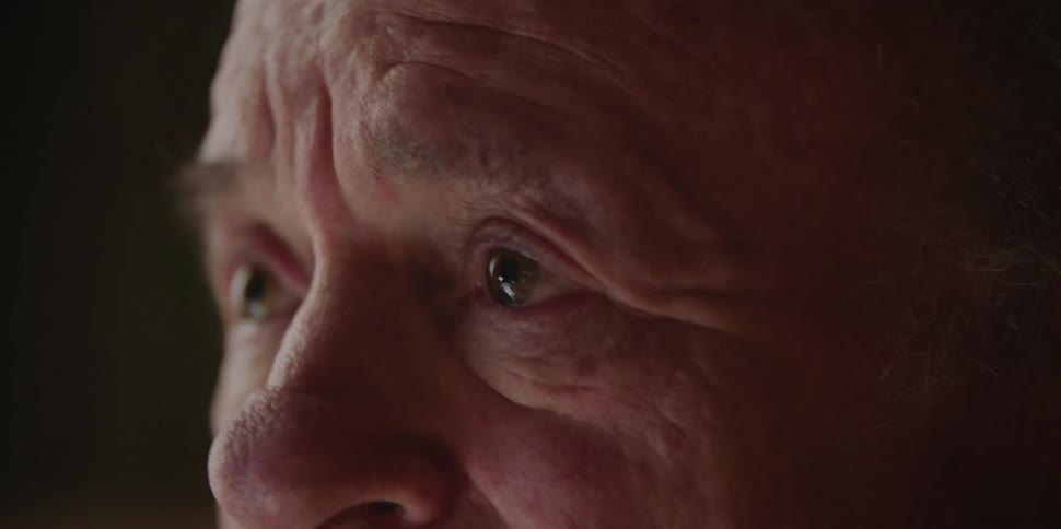 A man shakes his head while appearing on the verge of tears