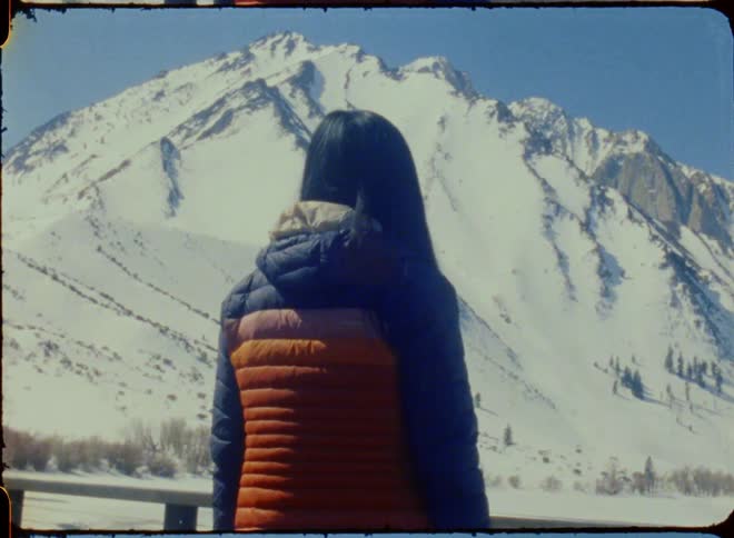 A woman stands before the mountain