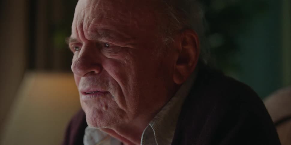 An elderly man is sitting down and talking to someone