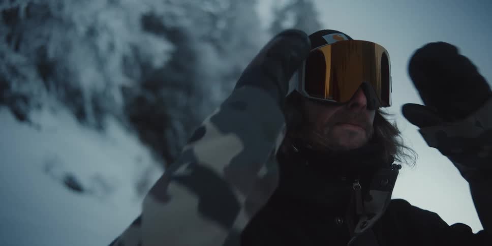 A man is wearing goggles in a wooded area