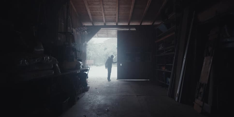 A man opens and walks into his garage