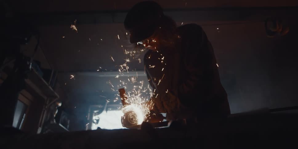 A man is using machinery in his garage