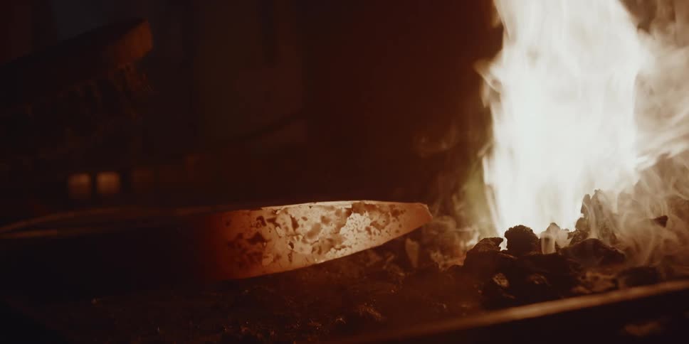 A person is welding a tool over a flame