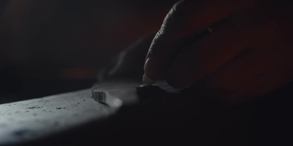 Male blacksmith in his workshop marking his piece with chalk during the day