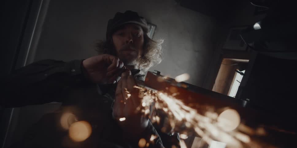 A man holds a welding tool against a metal object
