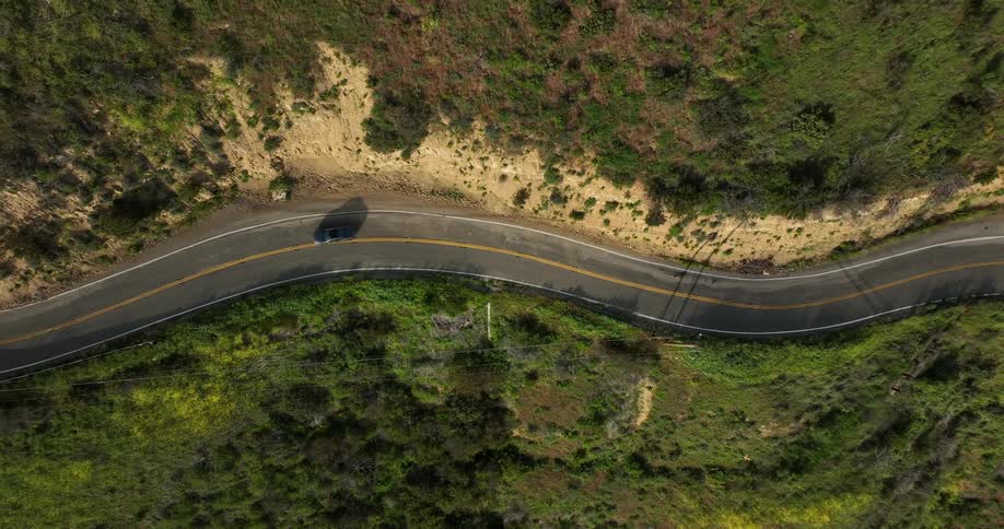 Aerial view of car driving on winding road