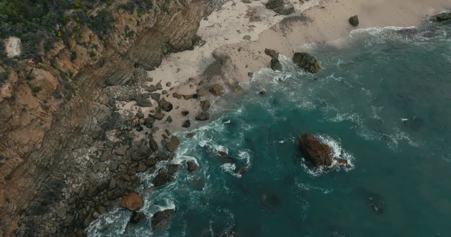 Dramatic aerial of waves crashing on beach
