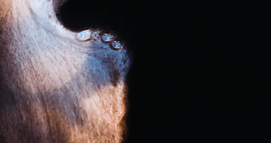 Close up distorted footage of colorful lights behind a glass