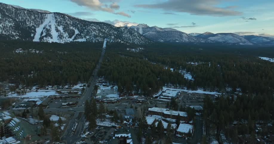 A small town in winter surrounded by trees and mountains