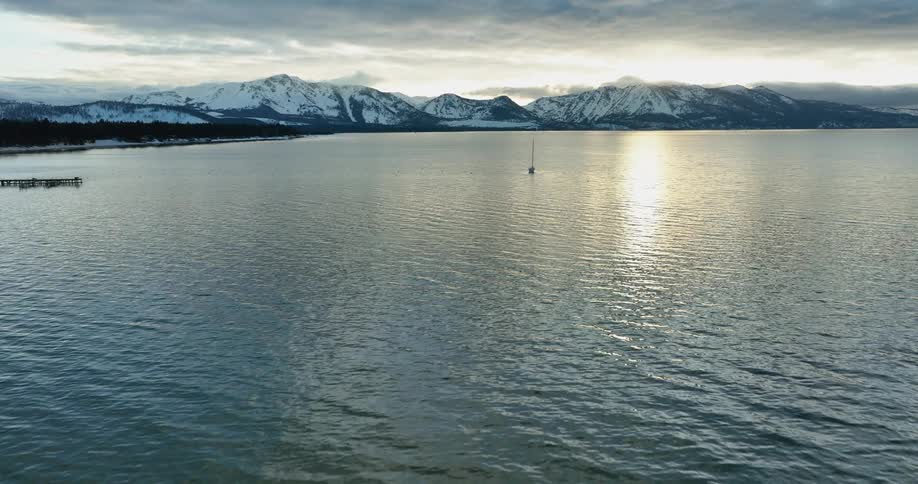 Aerial view of boat traveling on the ocean near snowy mountains