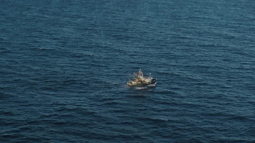 A fishing boat sails a calm sea