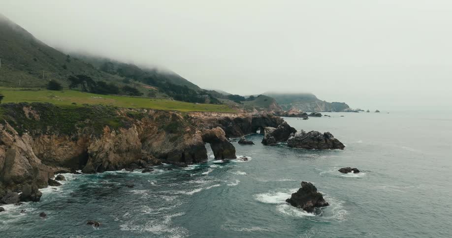 Rugged beach revealed behind grassy cliff