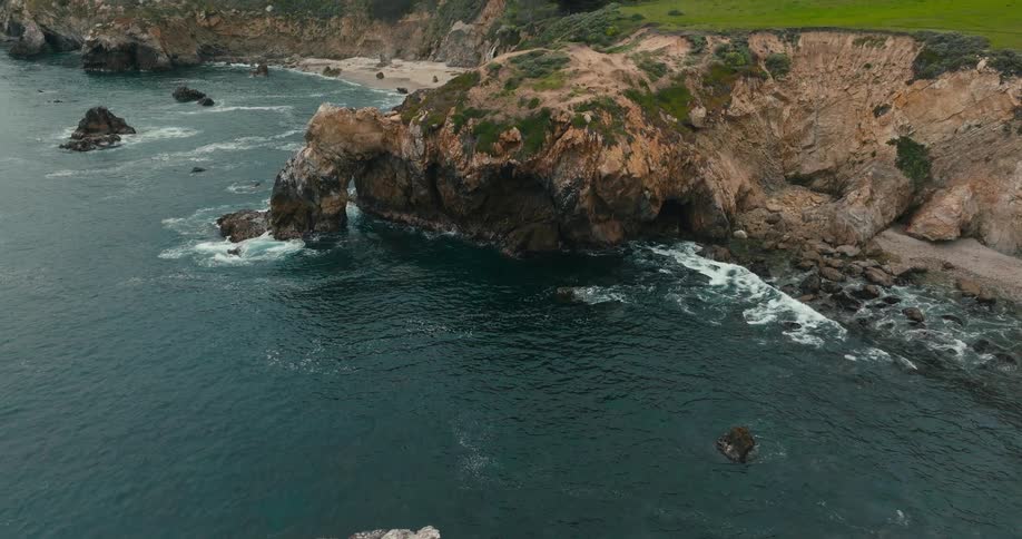 FPV drone aerial of rugged ocean and beach