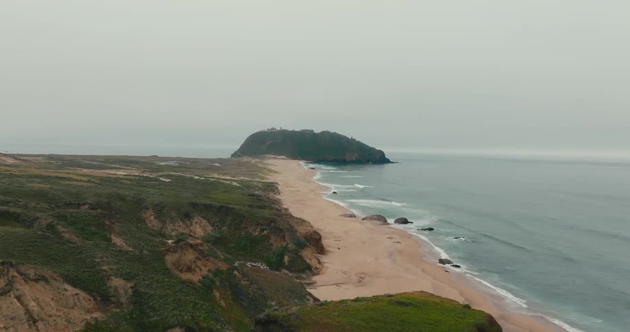View of remote beach with grassy cliffs