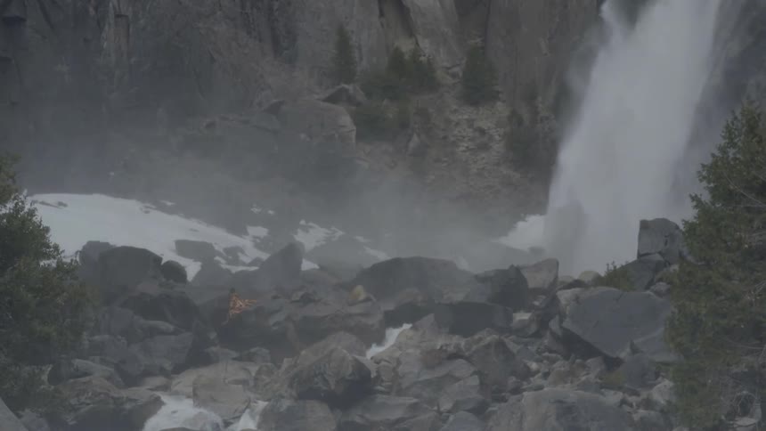A waterfall streaming in a rocky area with trees