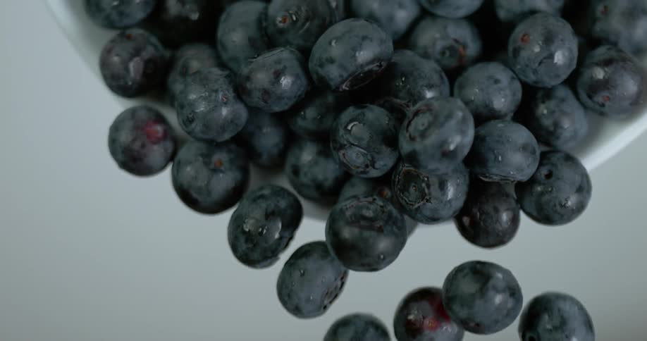 A bowl full of blueberries is poured out