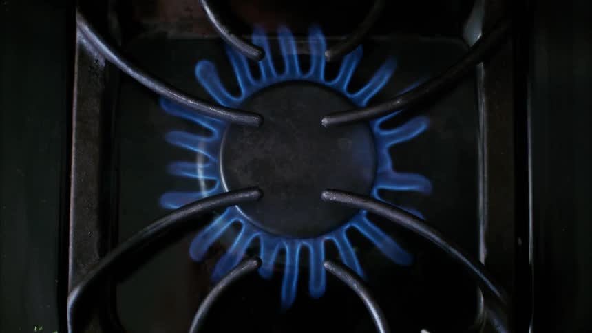 A gas flame burning on a stovetop