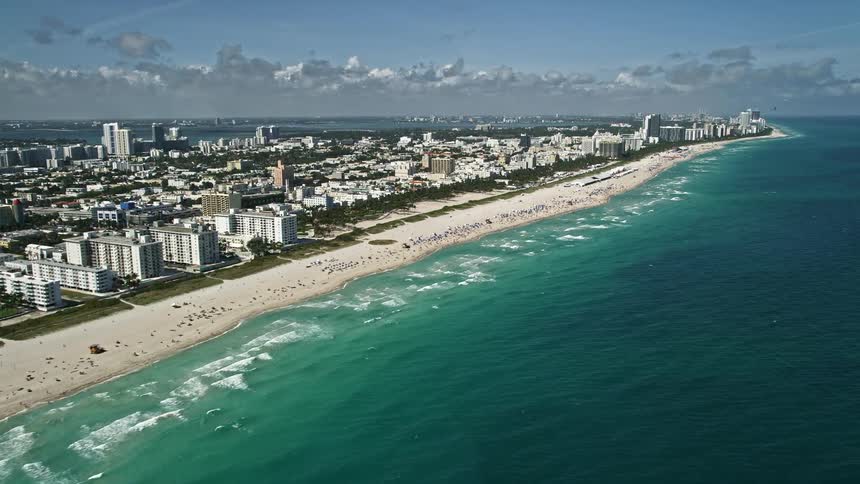 A breathtaking 5K aerial view of South Beach Miami showcasing the clear blue ocean sandy beaches buildings and people enjoying the sunny day