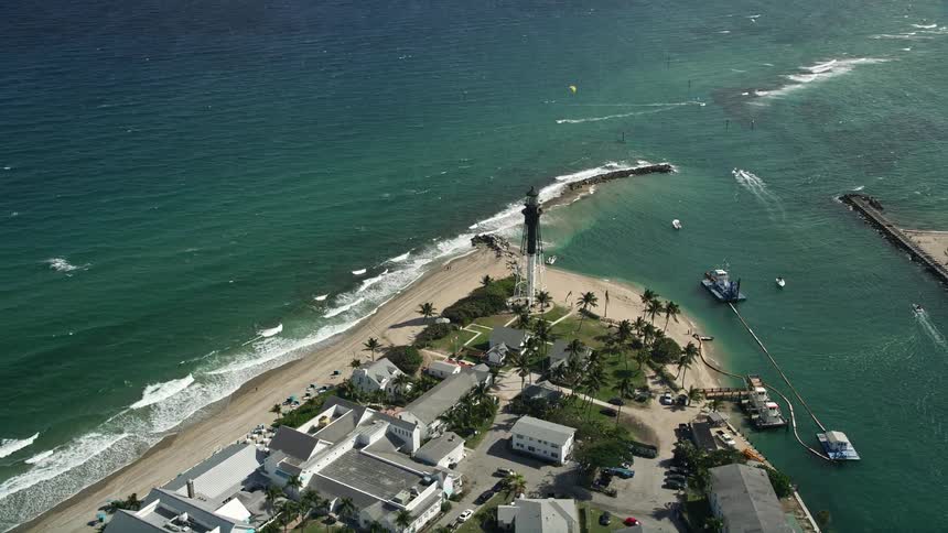 Drone aerial footage orbiting the Hillsboro Inlet Light an iconic lighthouse landmark overlooking the scenic shoreline of Hillsboro Beach Florida