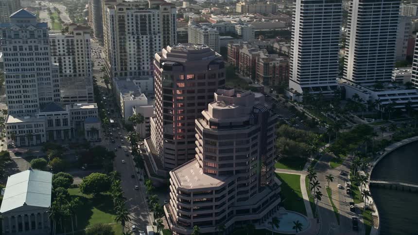 Aerial footage of towering waterfront office buildings in West Palm Beach Florida on a partly cloudy day