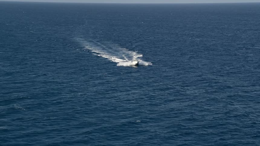 A fishing boat cruises the Atlantic Ocean off Palm Beach Shores Florida on a partly cloudy day