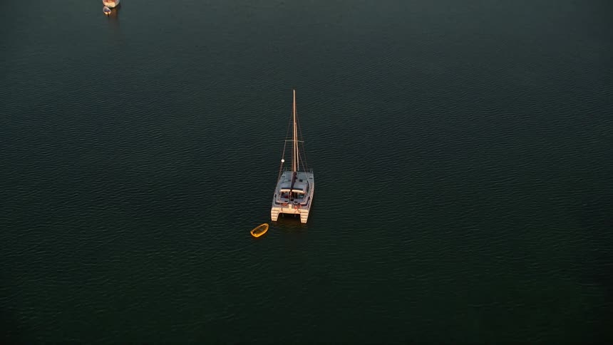 Approaching a catamaran and sailboats during dusk at sunset sailing around the Florida Keys in Key Largo