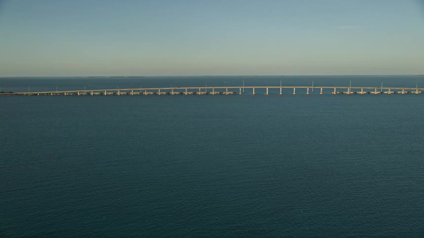 Approaching a large low bridge at dusk on Overseas Highway Long Key Florida with a beautiful sunset view
