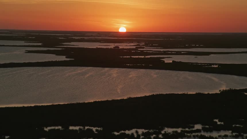 Aerial view of mangrove islands and water body at dusk approaching Key Largo Florida during sunset