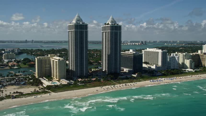 A high-flying aerial view of Miami Beachs Blue and Green Diamonds as well as other waterfront condos on the coastline offering a majestic sight of Floridas southern shores during the day