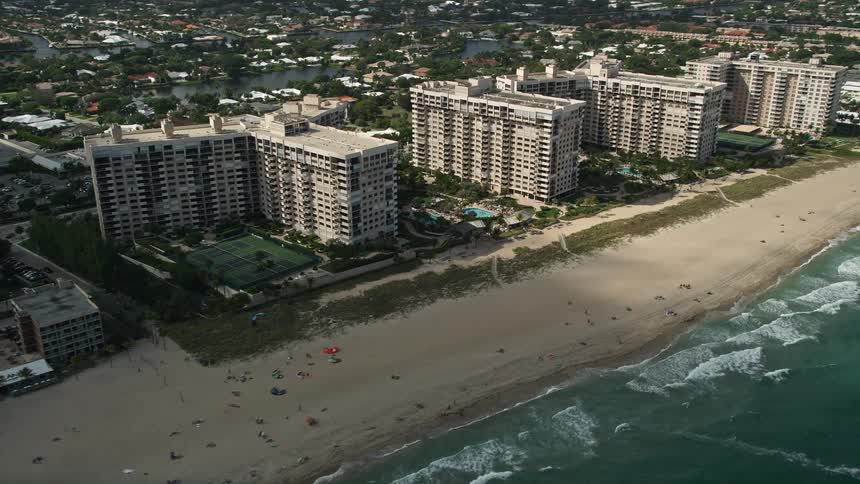 A sunny day at Lauderdale by the Sea Florida flying over apartment buildings and sunbathers on the beach